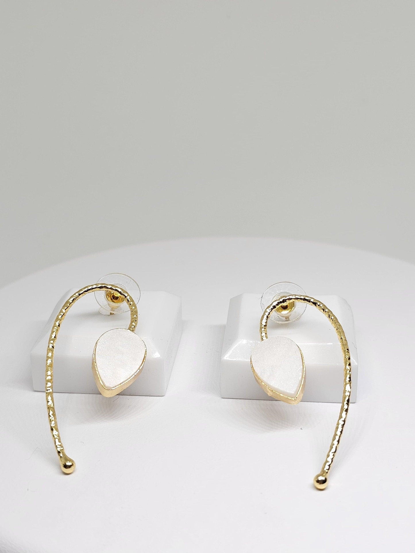 Beautifully designed brass earrings with a polished white stone, featuring a curved dangle style for a modern and sophisticated look