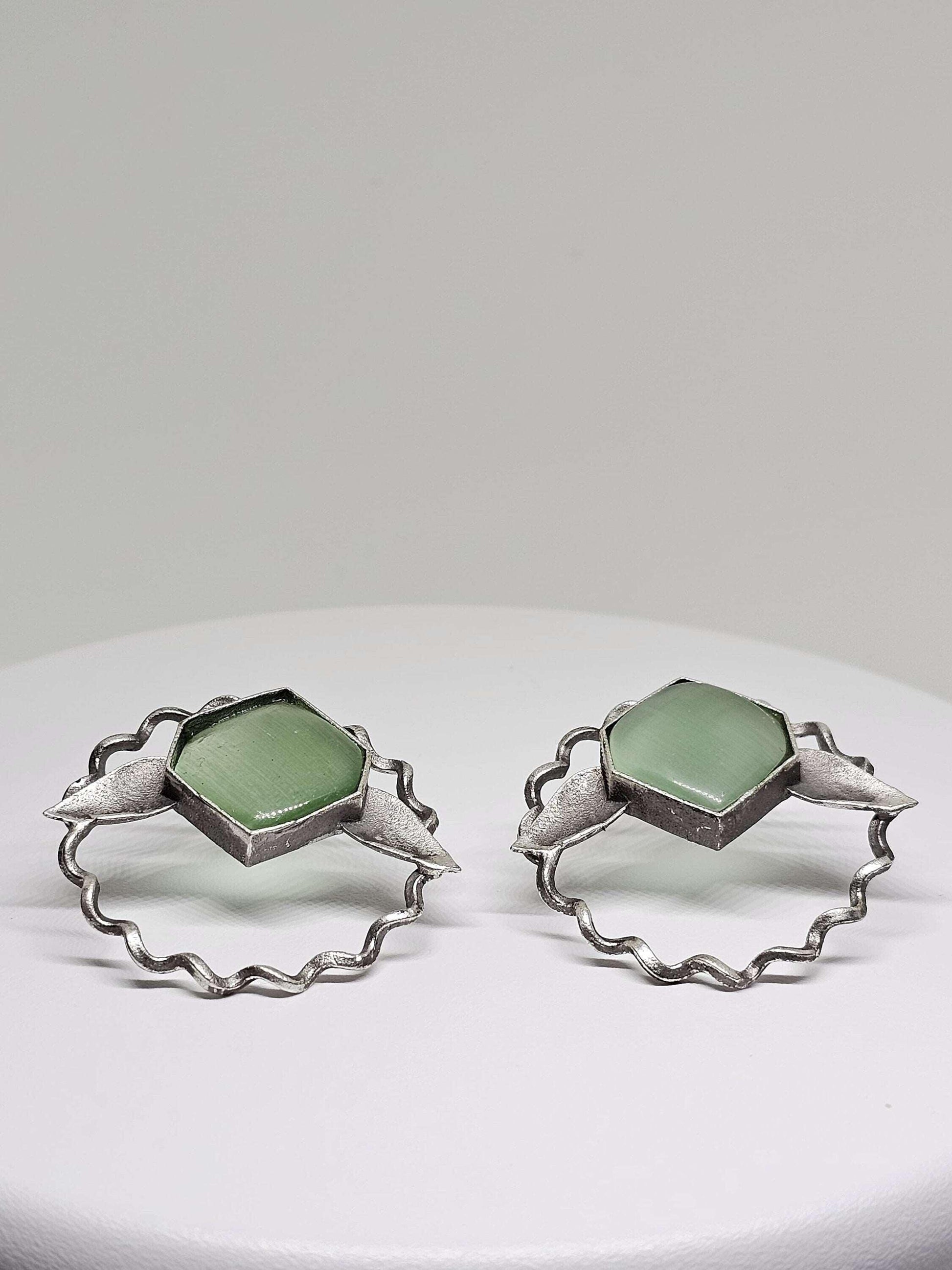 Elegant and lightweight brass leaf-shaped stud earrings featuring striking green Monalisa stones, showcasing a chic and nature-inspired design ideal for both casual and formal wear.
