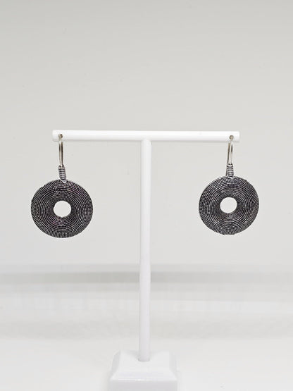 Handcrafted oxidised silver earrings featuring intricate circular design, displayed elegantly