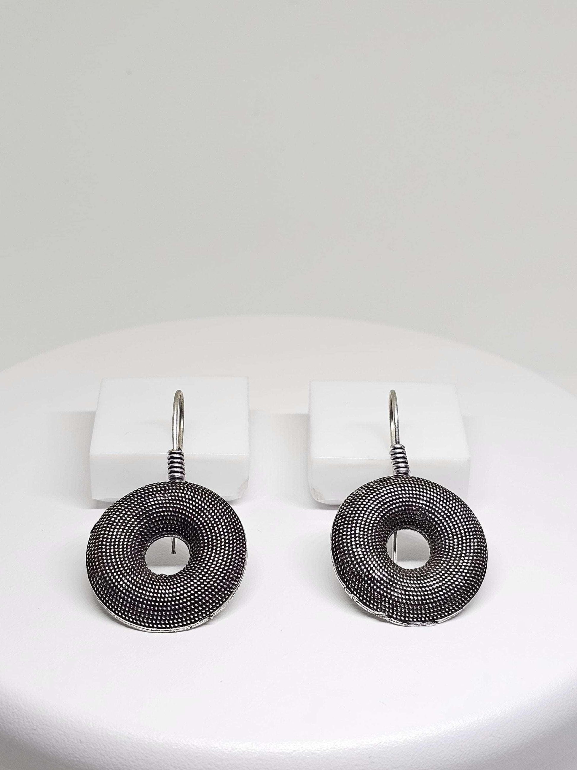 Oxidised silver round earrings with textured donut design on white background, perfect for women.