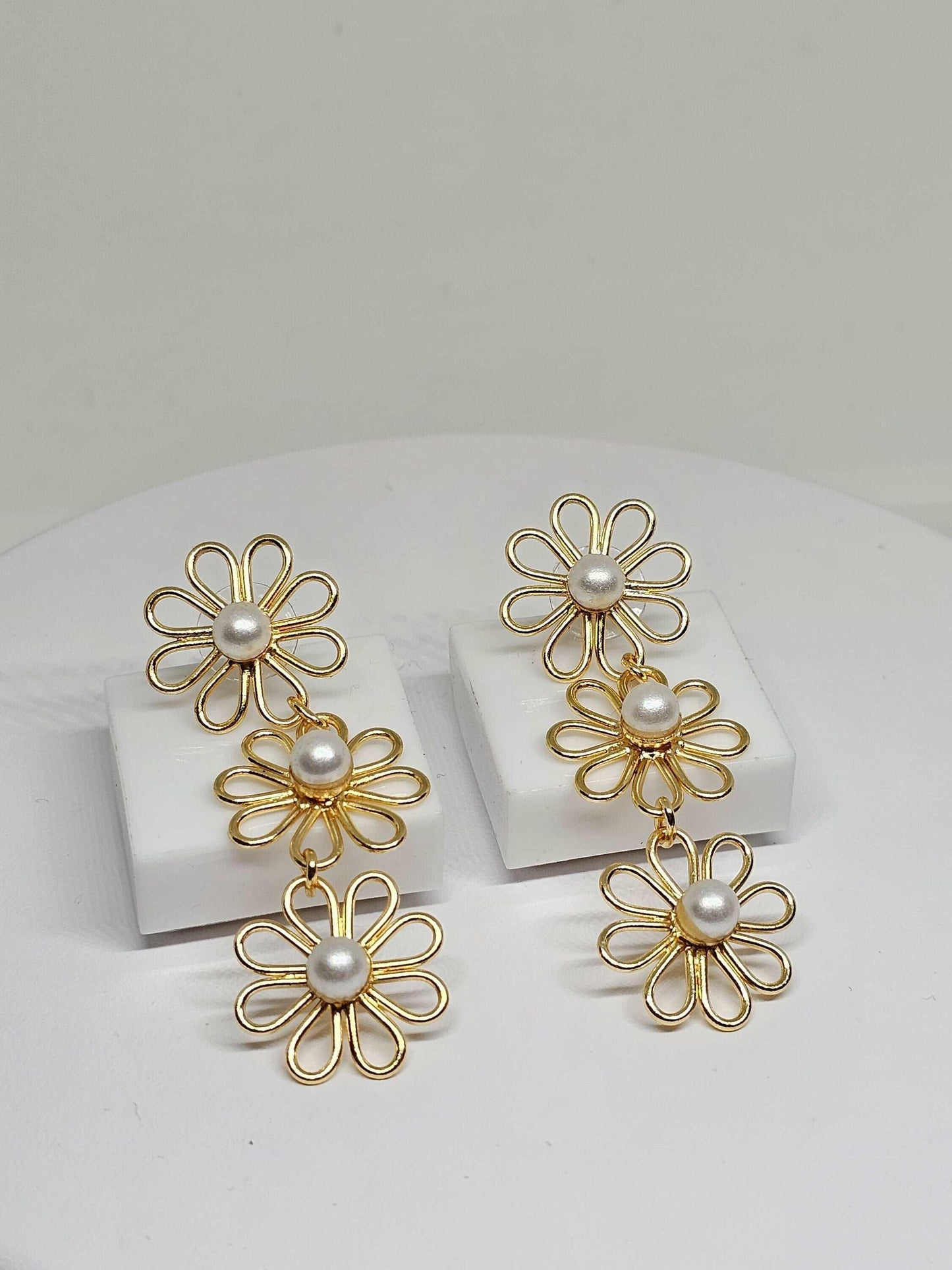 exquisite gold flower earrings with shiny pearl centers, combining elegance with a delicate floral design, making them a versatile accessory for any jewelry collection.