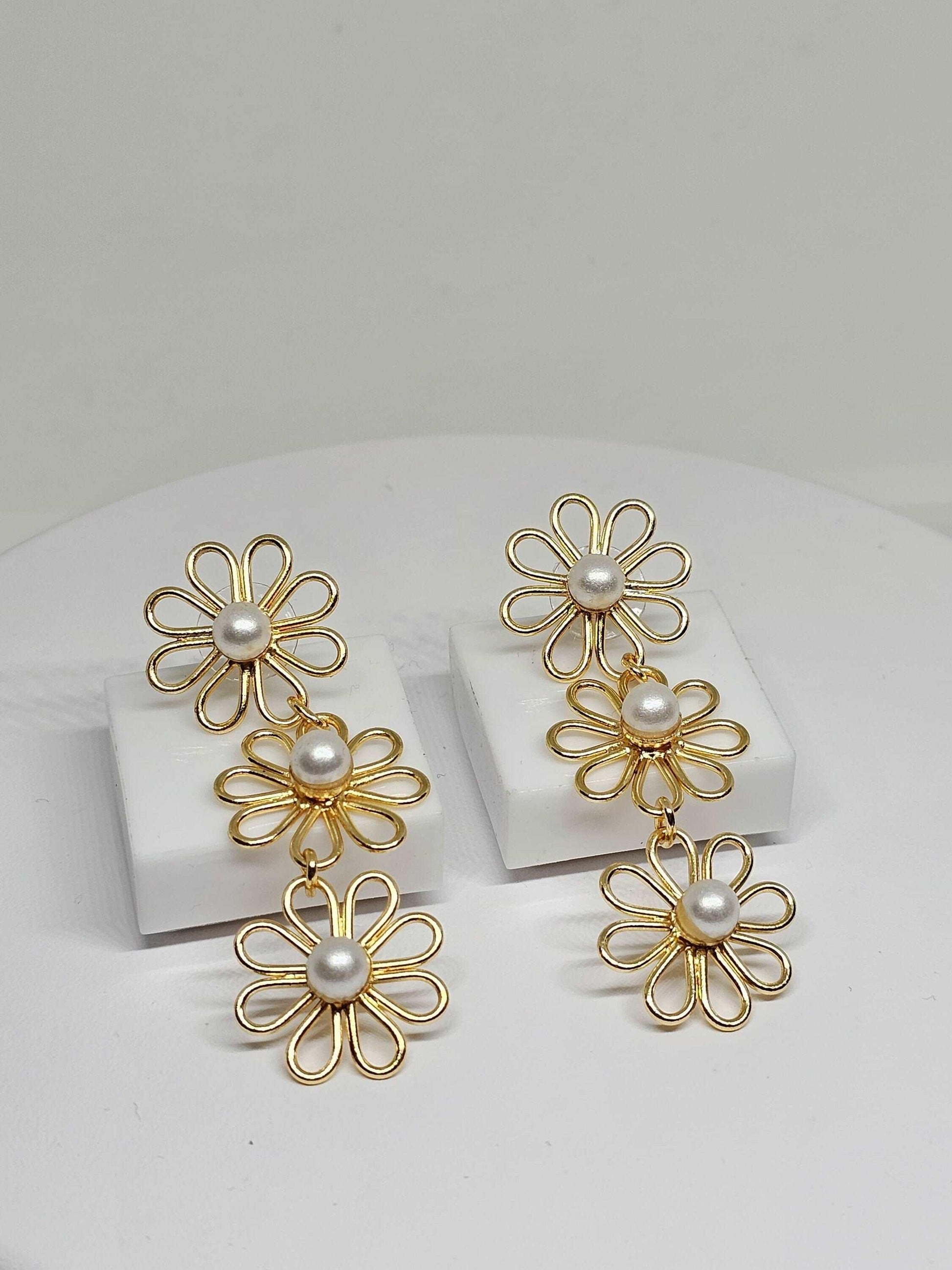 exquisite gold flower earrings with shiny pearl centers, combining elegance with a delicate floral design, making them a versatile accessory for any jewelry collection.