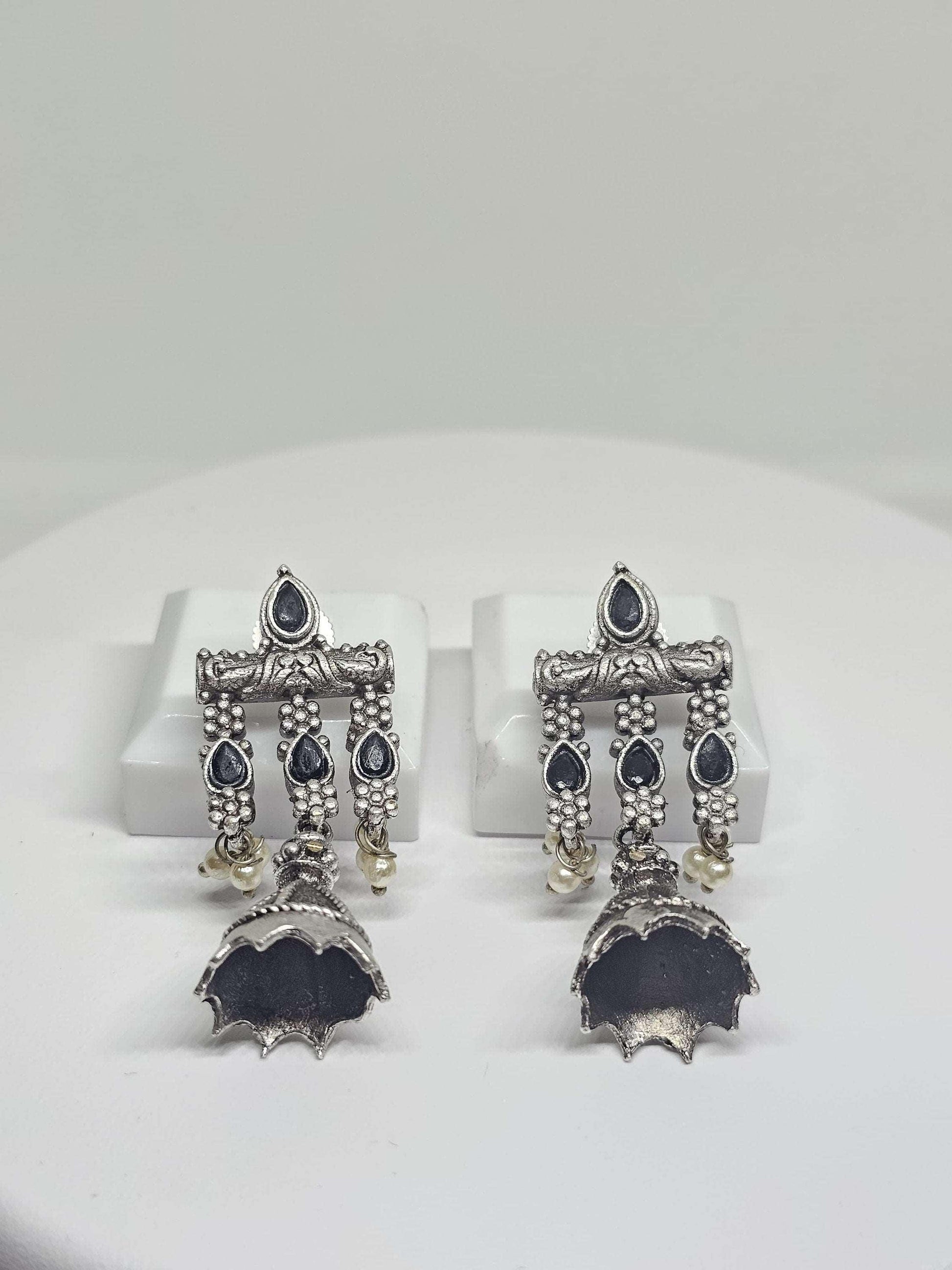 Handmade oxidised silver Jhumka earrings with black stones and hanging white pearls, ideal for ethnic and formal occasions.