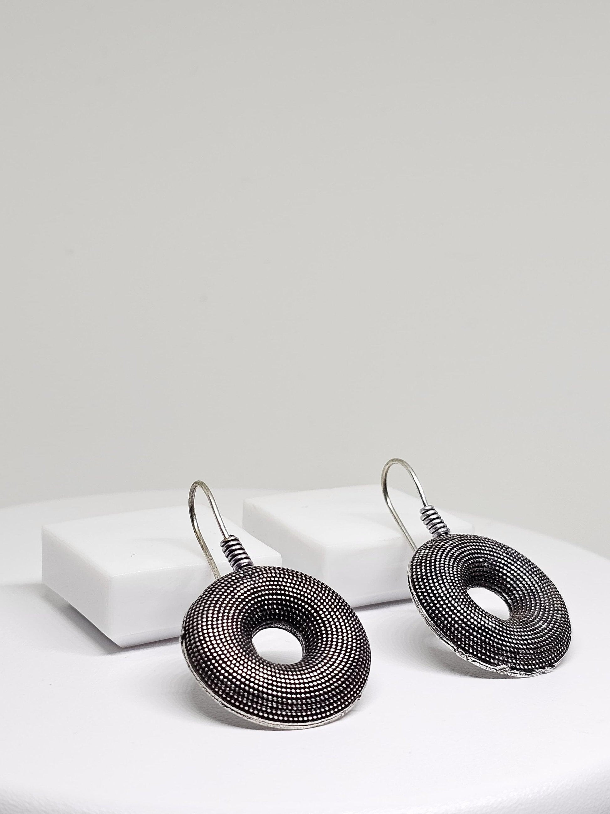 Stylish oxidised silver earrings with unique donut shape and detailed texture, ideal for any occasion.