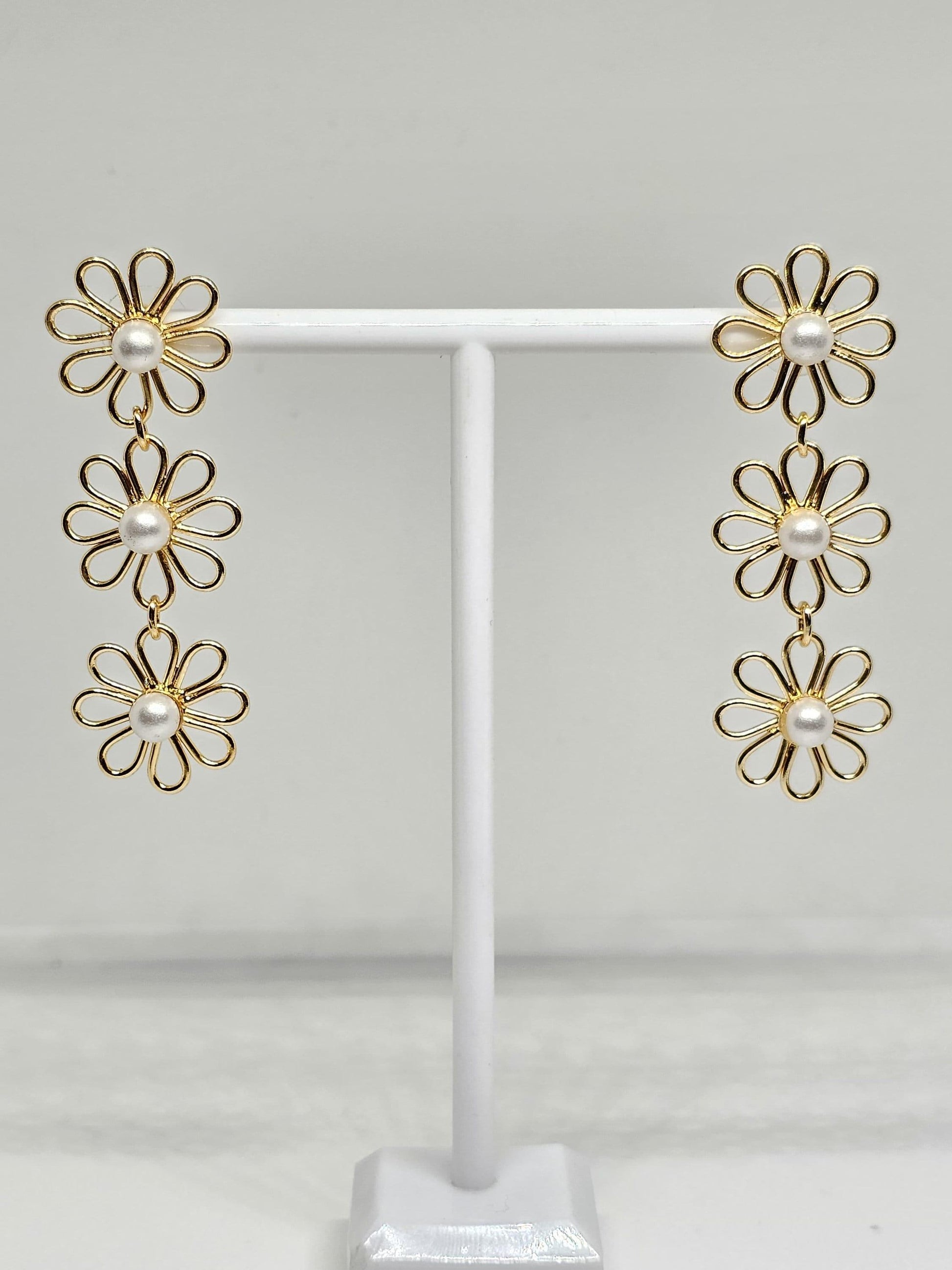 Delicate floral jewelry with gold plating and pearl accents, highlighting a handcrafted double flower arrangement, ideal for enhancing any outfit with a touch of timeless beauty.