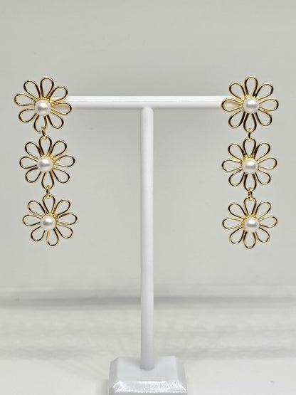 Delicate floral jewelry with gold plating and pearl accents, highlighting a handcrafted double flower arrangement, ideal for enhancing any outfit with a touch of timeless beauty.