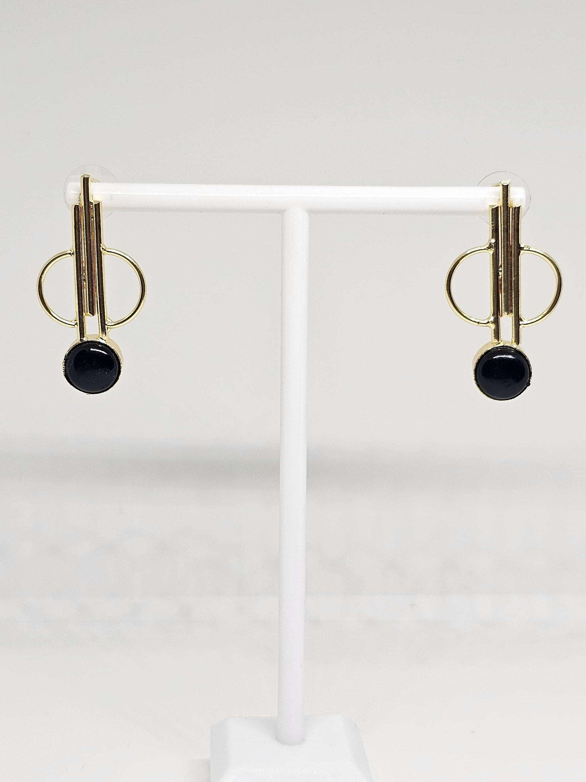Close-up of simple brass hoop earrings displayed on a white stand, showcasing their lightweight and stylish design, ideal for casual or formal occasions, adding a subtle touch of elegance