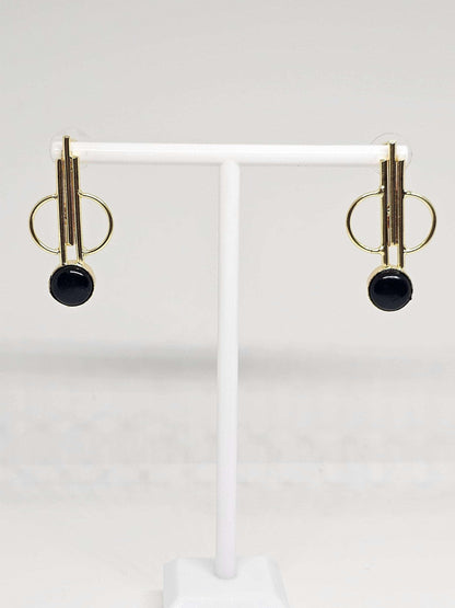Close-up of simple brass hoop earrings displayed on a white stand, showcasing their lightweight and stylish design, ideal for casual or formal occasions, adding a subtle touch of elegance