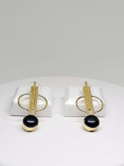 Unique gold and natural stone earrings displayed on a stand, featuring an artistic design with natural stone elements and brass, perfect for adding a creative and stylish touch to any ensemble