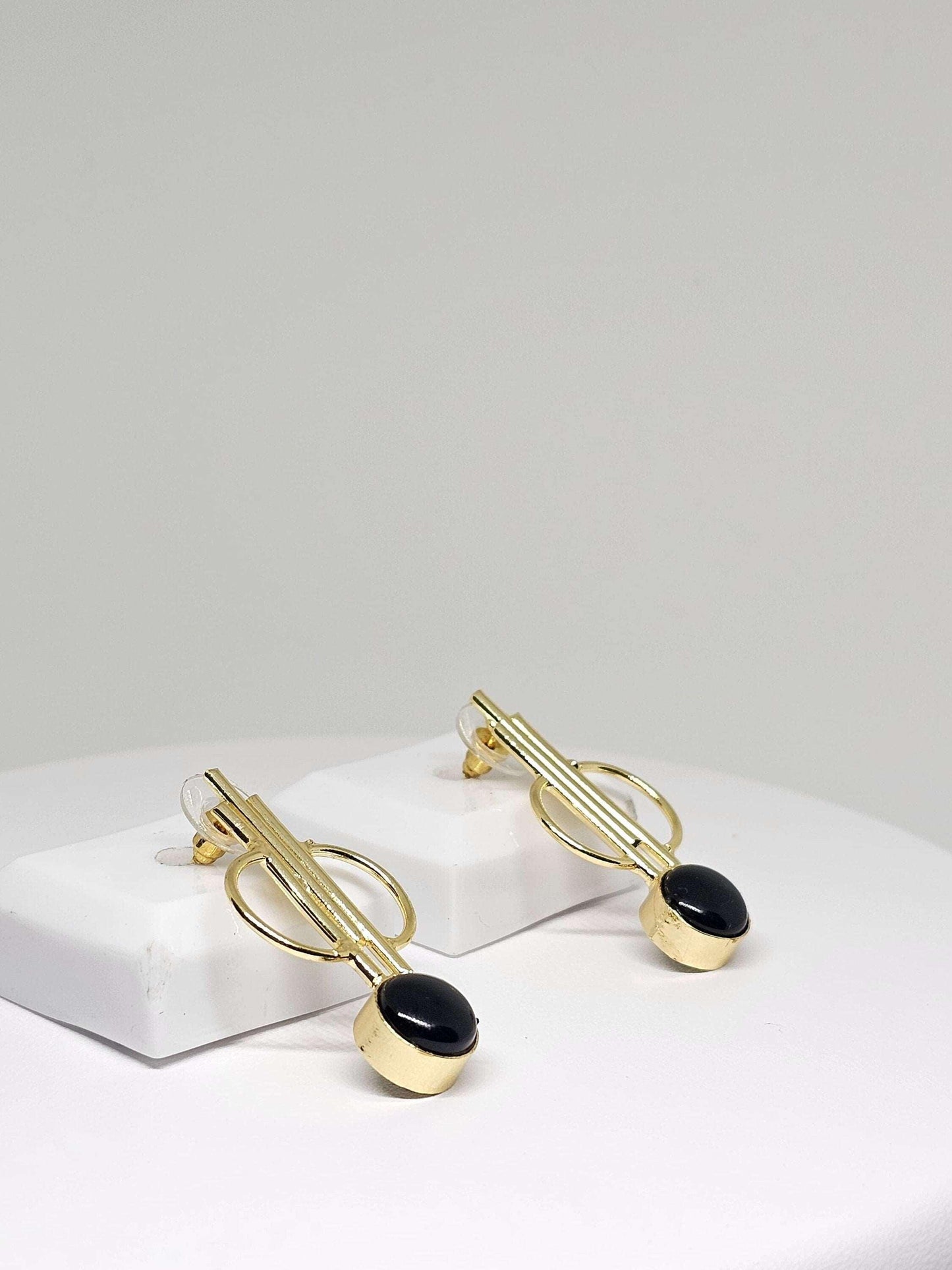 Elegant gold hoop earrings on a white background, featuring a simple and minimalist open circle design made of high-quality brass, perfect for everyday wear or adding a touch of style to any outfit.