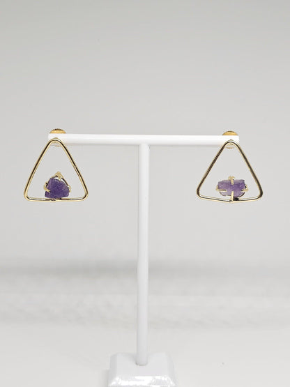 Detailed view of brass triangle earrings featuring raw amethyst stones, combining modern geometric design with the organic beauty of amethyst