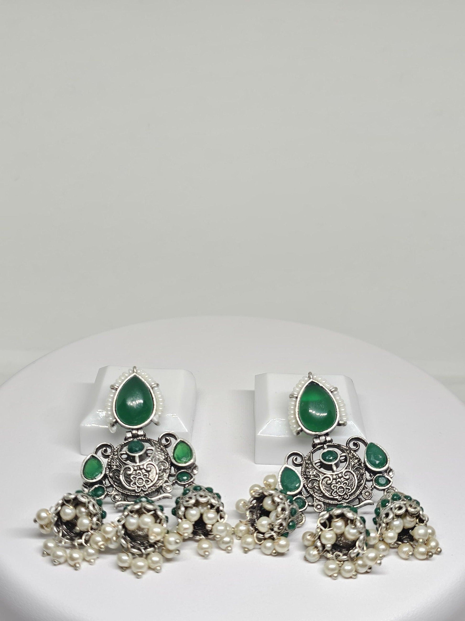 Ornate silver chandbali earrings with green stones and pearl drops, traditional Indian jewelry