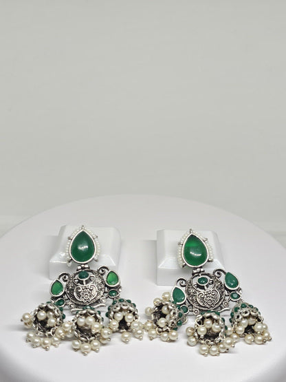 Ornate silver chandbali earrings with green stones and pearl drops, traditional Indian jewelry