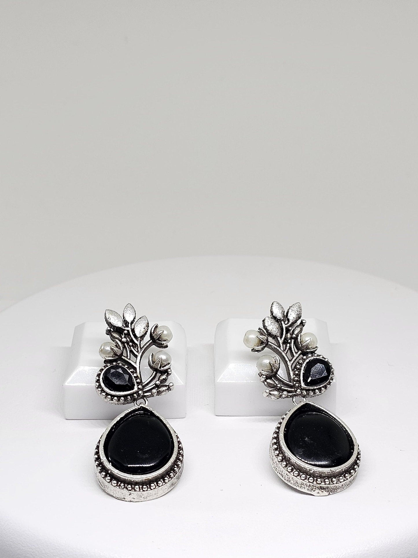 Elegant silver oxidized earrings featuring black stone and pearl details, perfect for ethnic wear