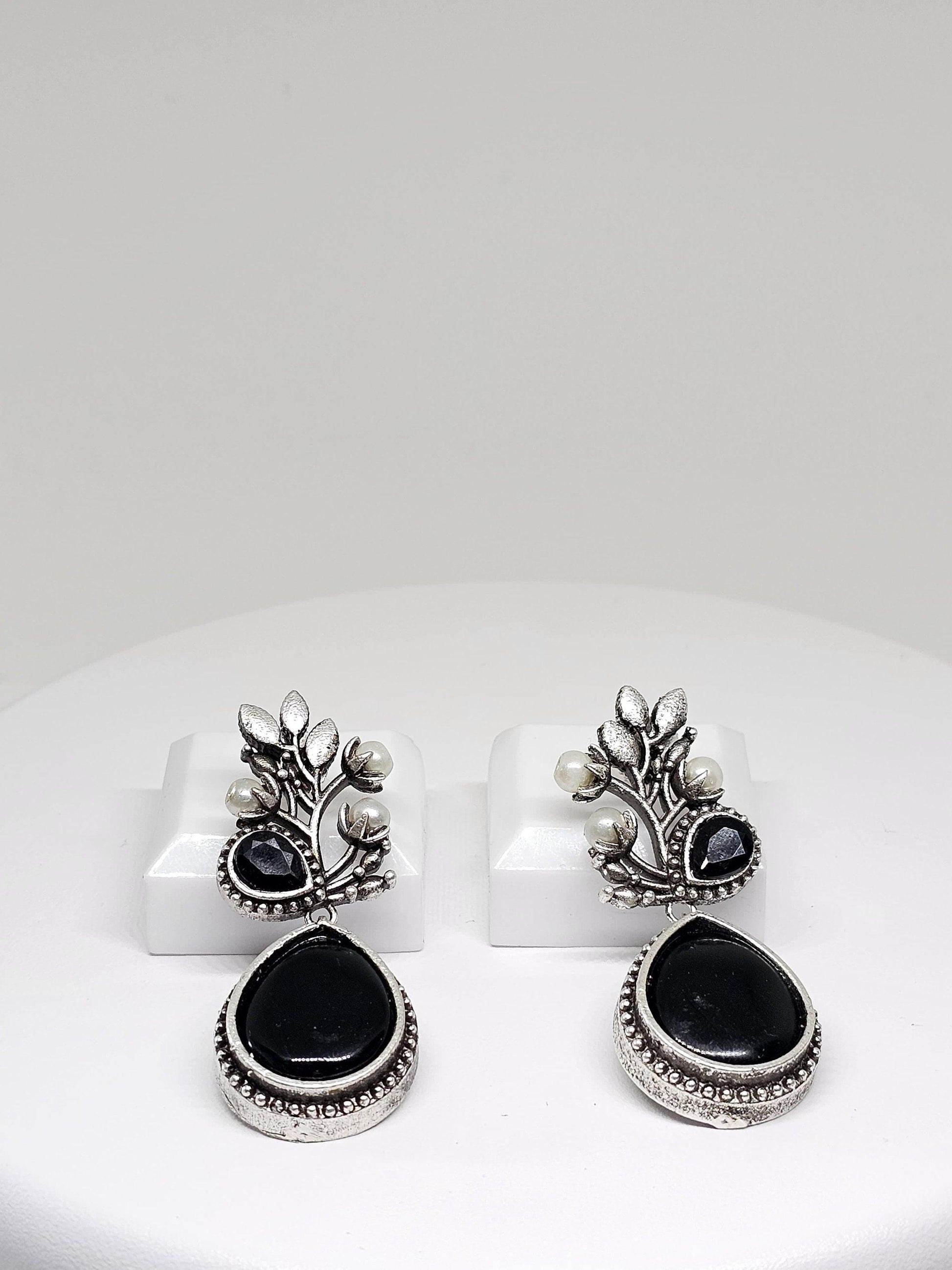 Elegant silver oxidized earrings featuring black stone and pearl details, perfect for ethnic wear