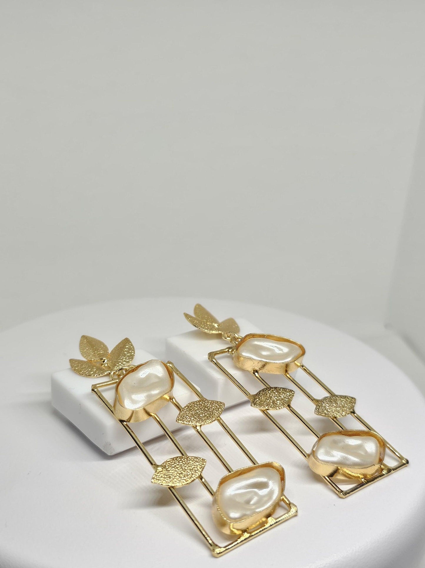 Elegant gold-plated earrings with mother of pearl stones and leaf detailing, perfect for sophisticated style
