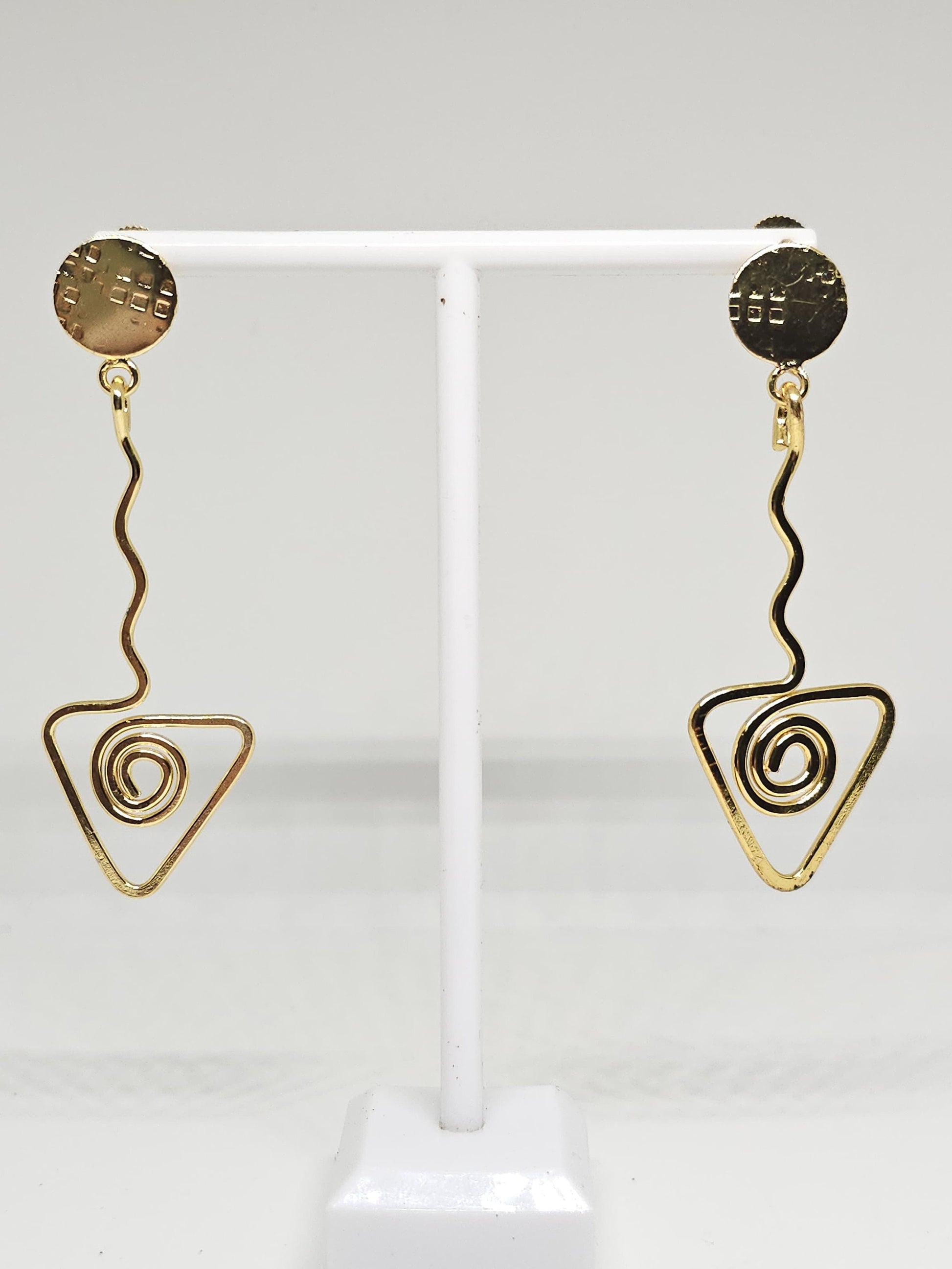 Minimalist brass earrings with a modern spiral triangle pendant and circular top