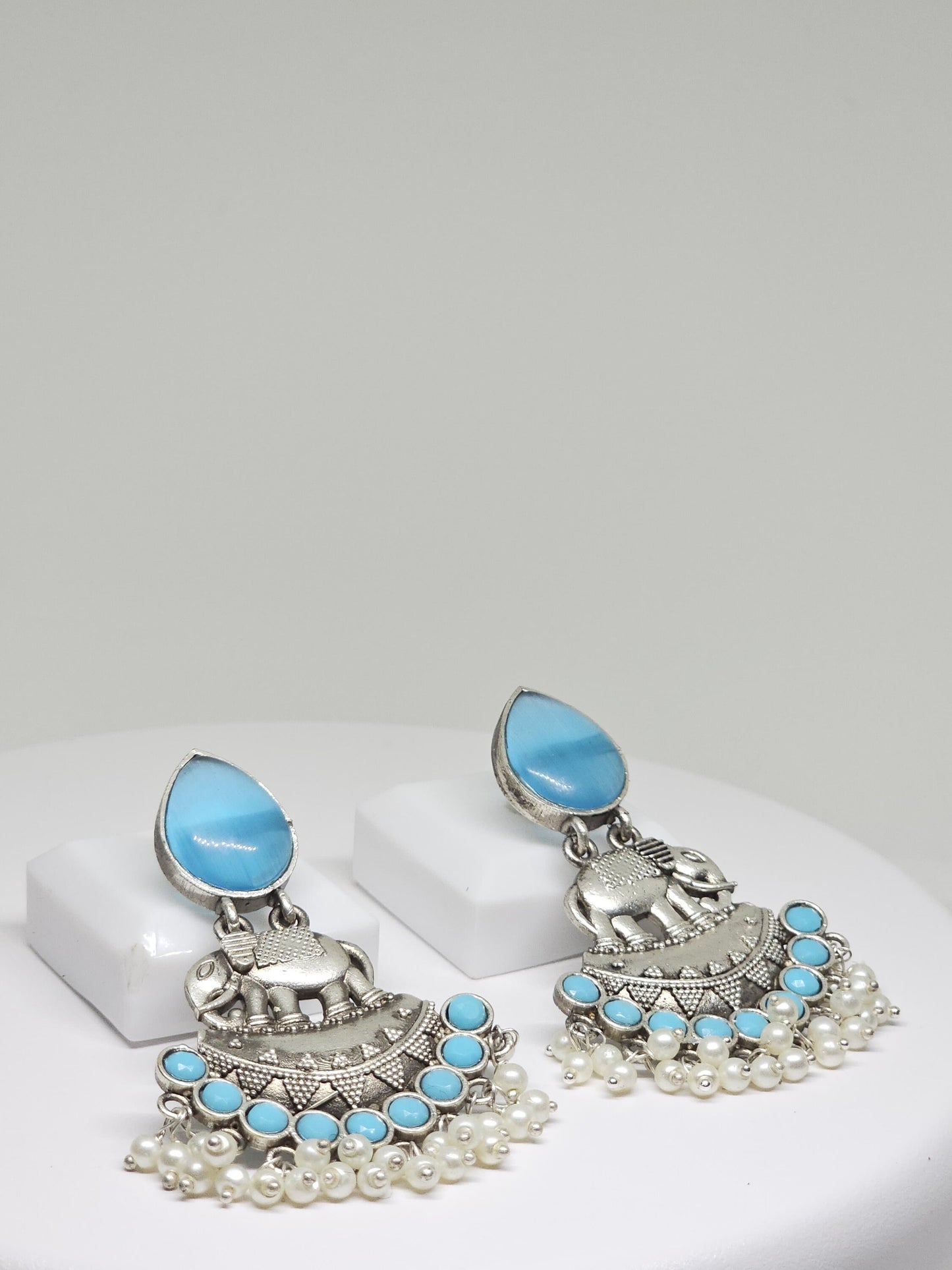 Artisan silver earrings featuring elephants, blue stones, and pearl drops, handmade ethnic jewelry
