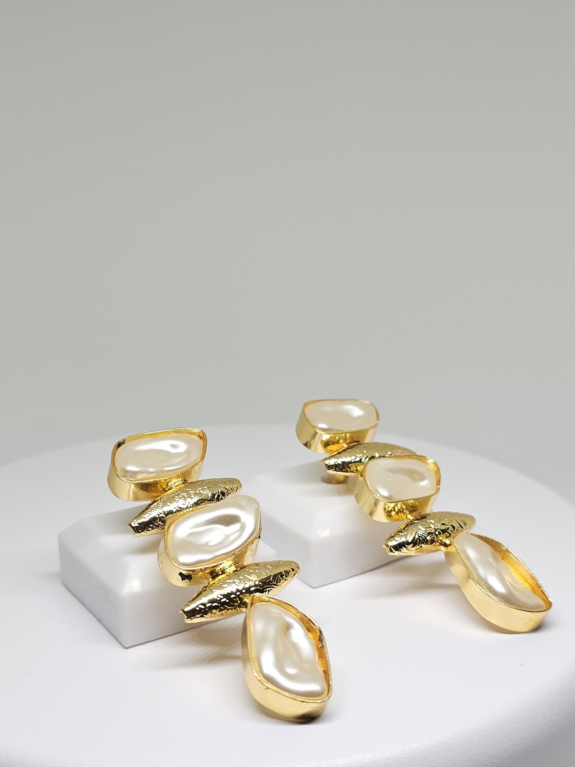 Modern geometric earrings with mother of pearl stones in a gold setting