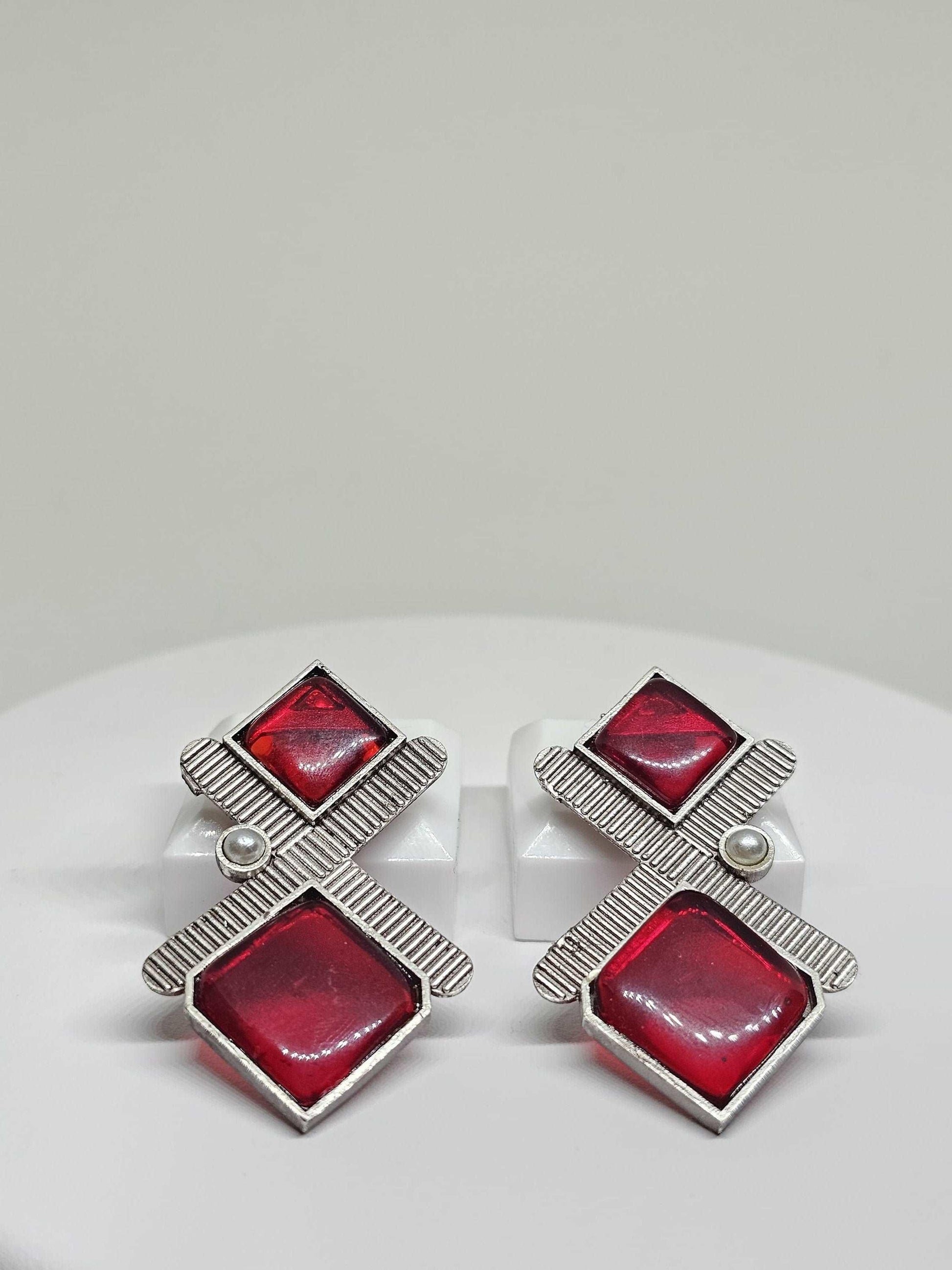 The earrings showcase a sleek geometric pattern and are available in both striking black and bold red, perfect for adding a contemporary touch to any outfit