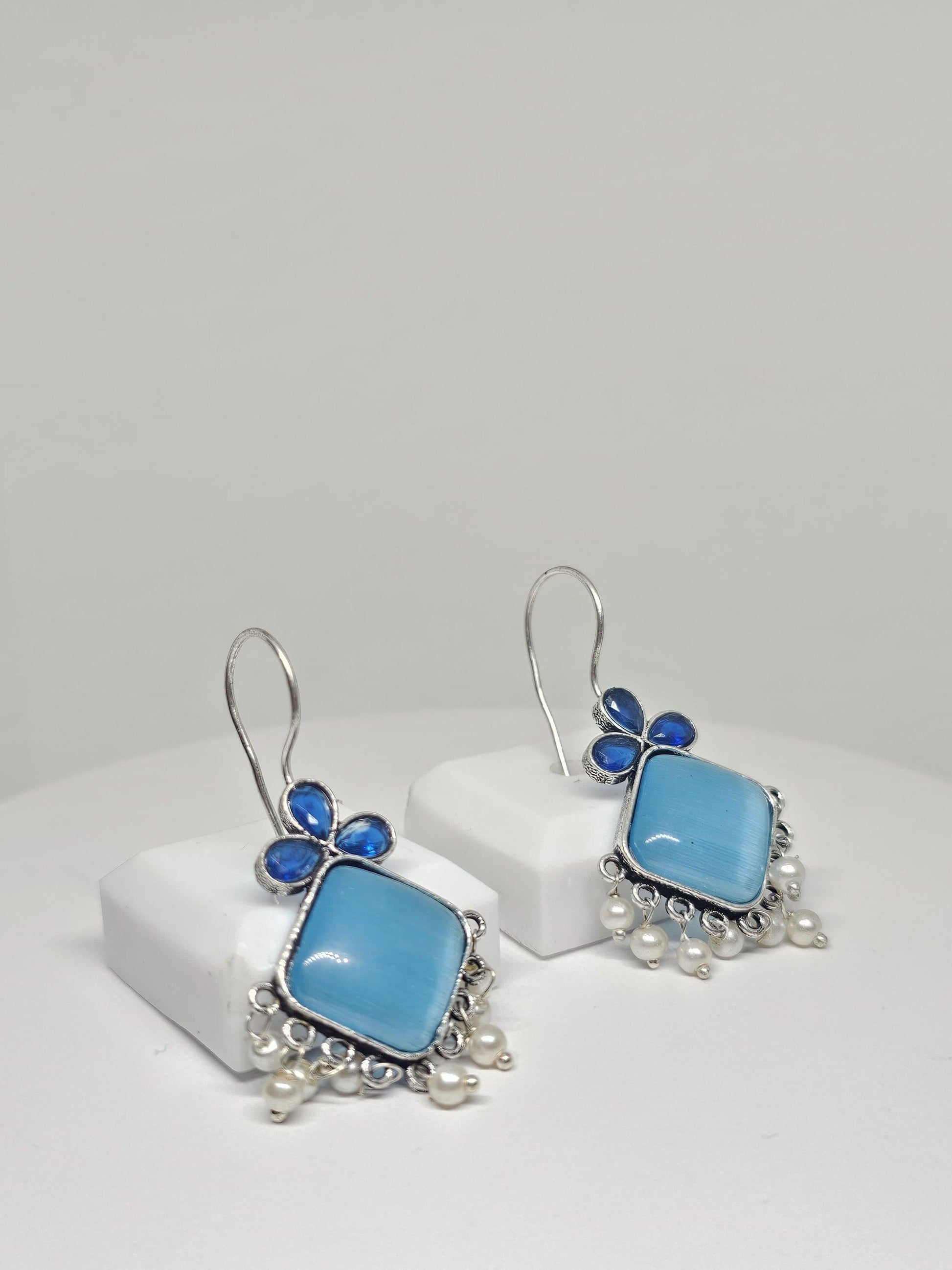 Boho silver dangle earrings with green gemstones.