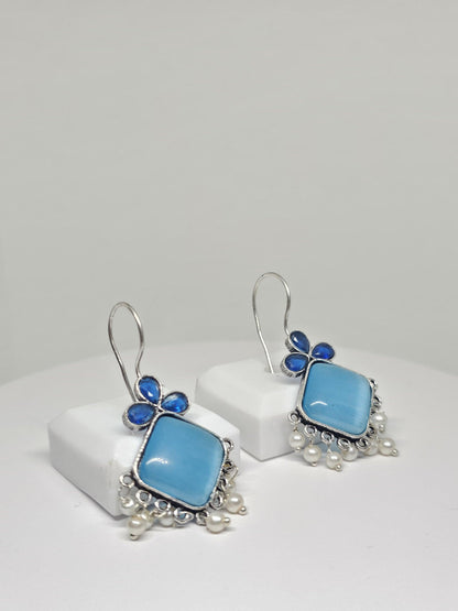 Boho silver dangle earrings with green gemstones.