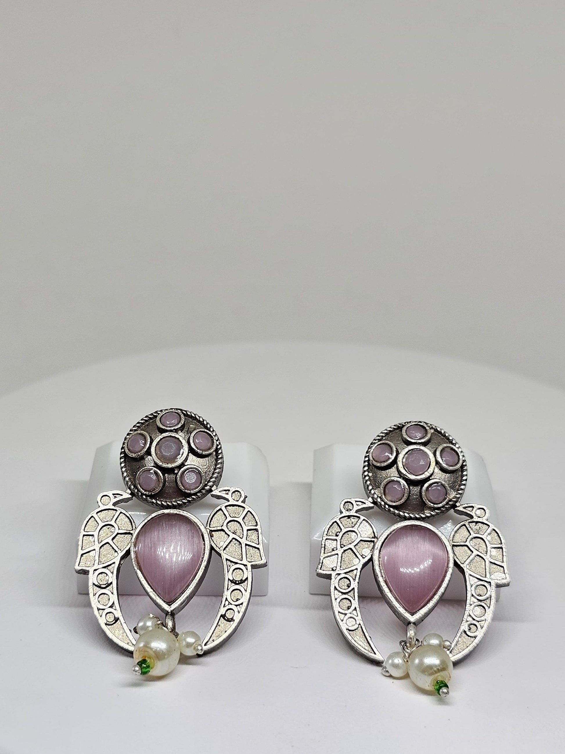 Boho-style silver earrings featuring pink gemstones and pearl dangles on a white background