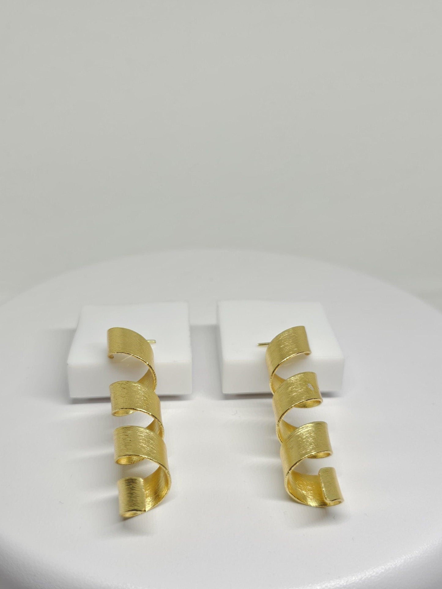 Gold-toned helix design earrings with a minimalist aesthetic, perfect for fashion-forward women