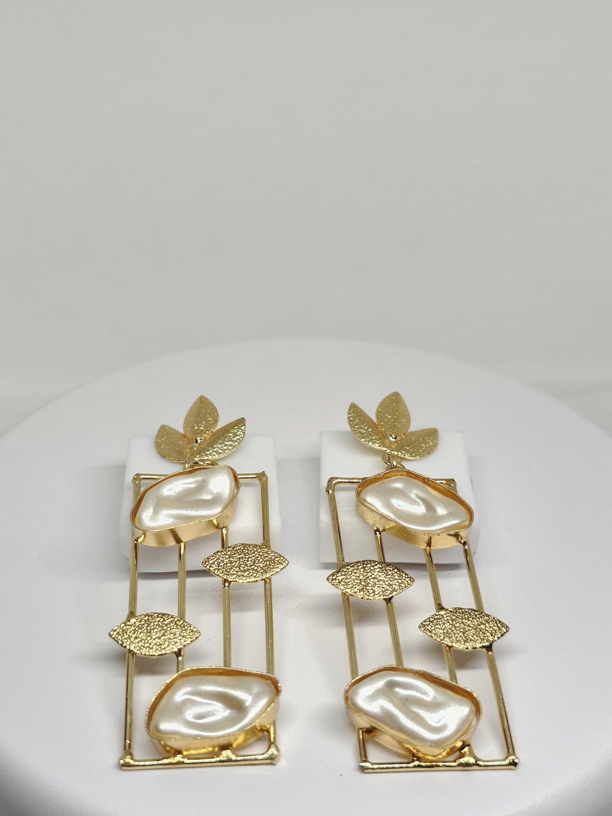 Handcrafted gold earrings featuring mother of pearl stones in a modern geometric design