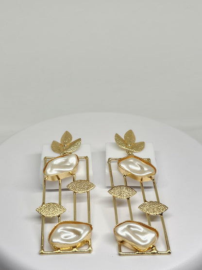 Handcrafted gold earrings featuring mother of pearl stones in a modern geometric design