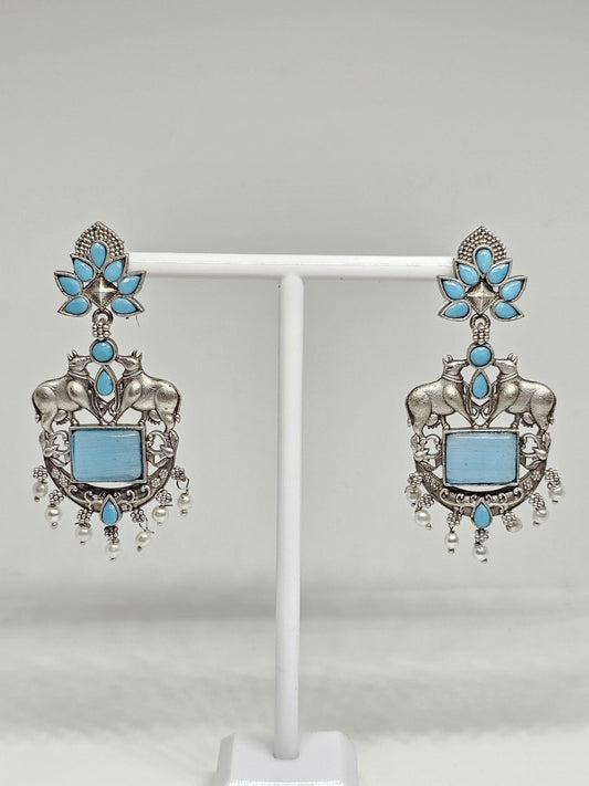Oxidized silver earrings with bull motifs, blue stones, floral designs, and pearl drop accents.