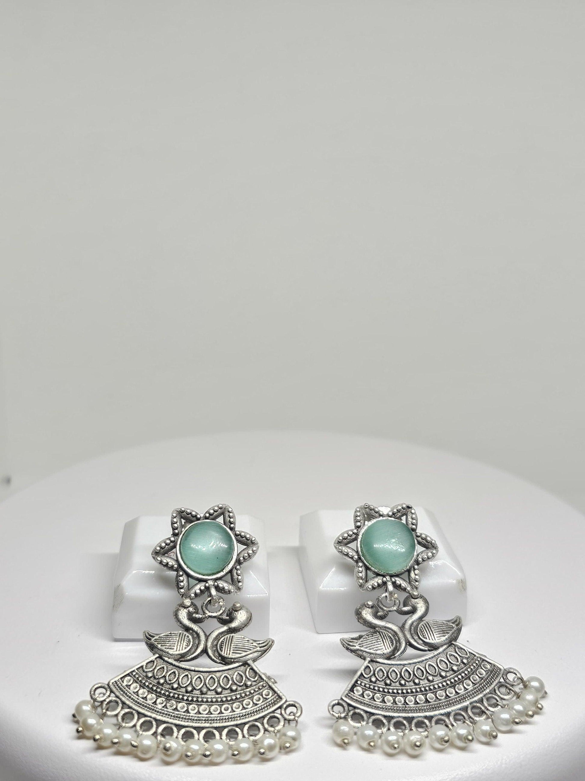 Oxidized silver earrings with duck motifs, greenish-blue stone, and pearl drops
