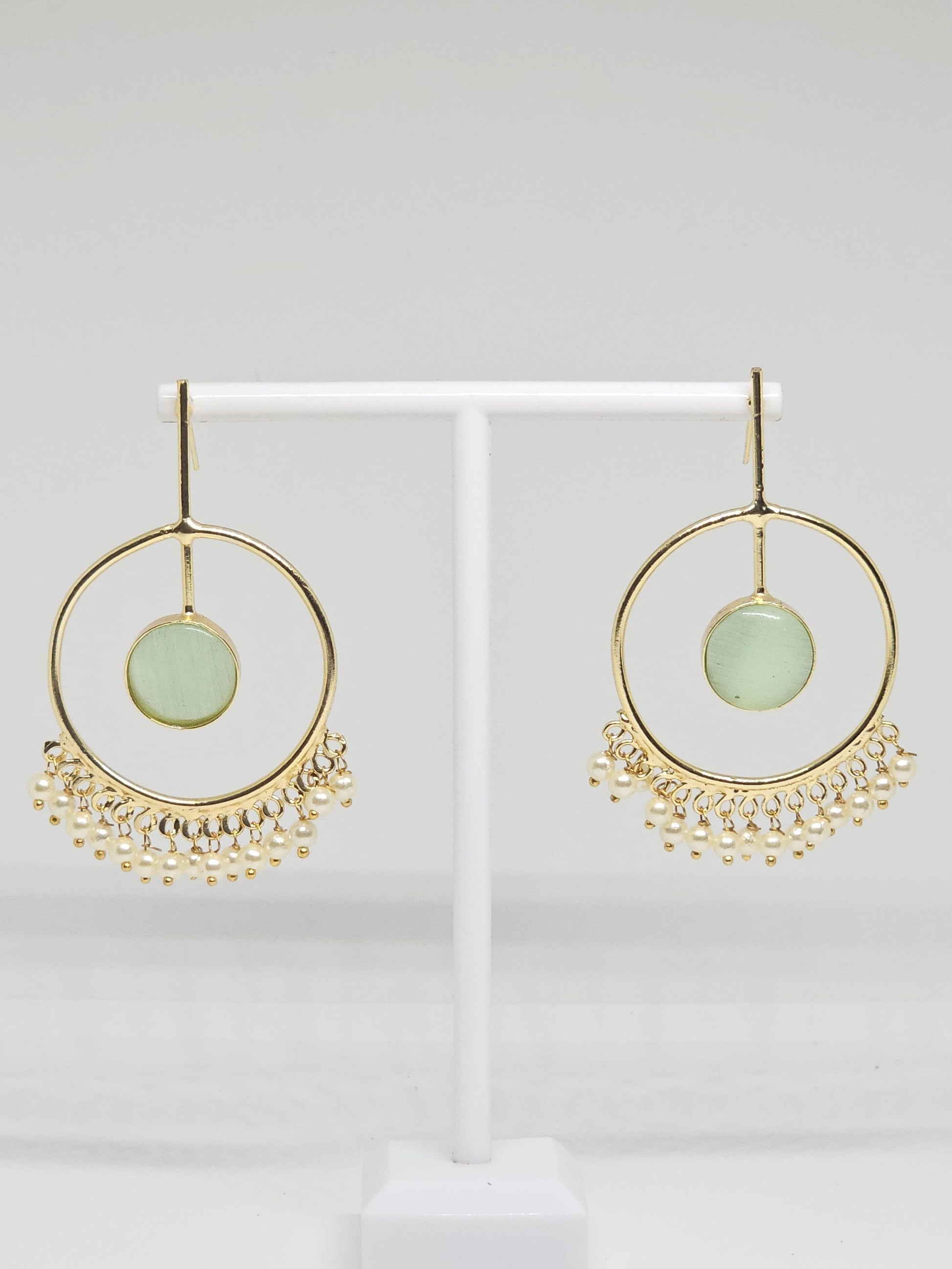 Gold-plated hoop earrings with green stone and pearl dangles on display