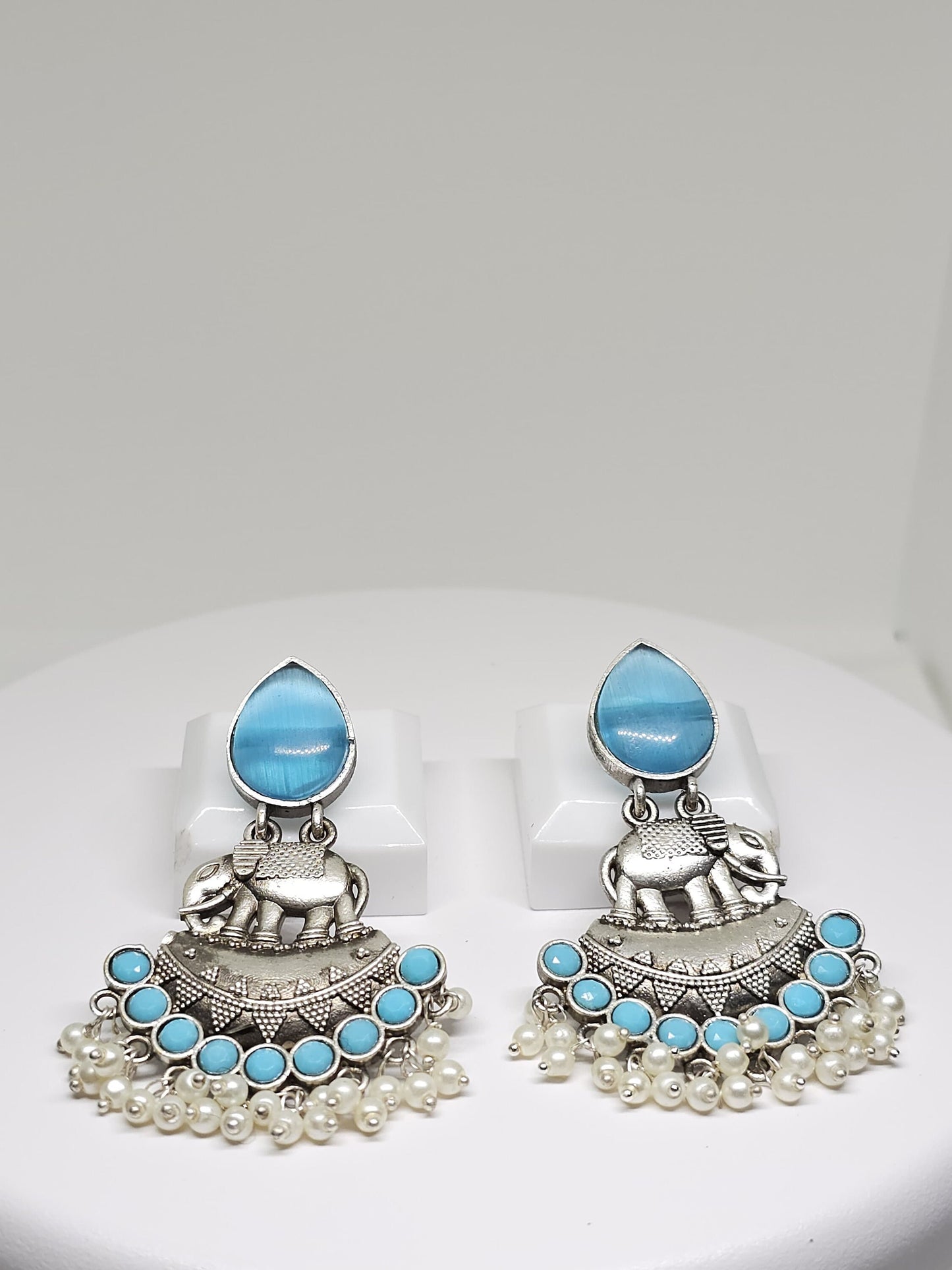 Silver elephant earrings with blue gemstones and pearl dangles, ethnic-inspired fashion accessory