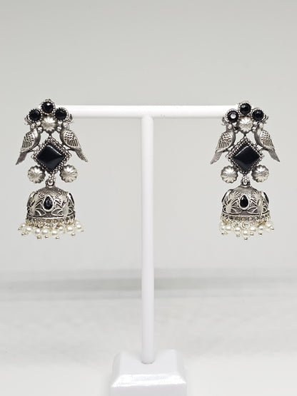 Handcrafted silver earrings with black stones, bird motif, and pearl accents