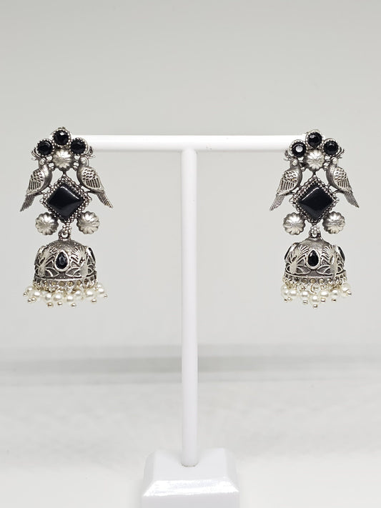 Handcrafted silver earrings with black stones, bird motif, and pearl accents