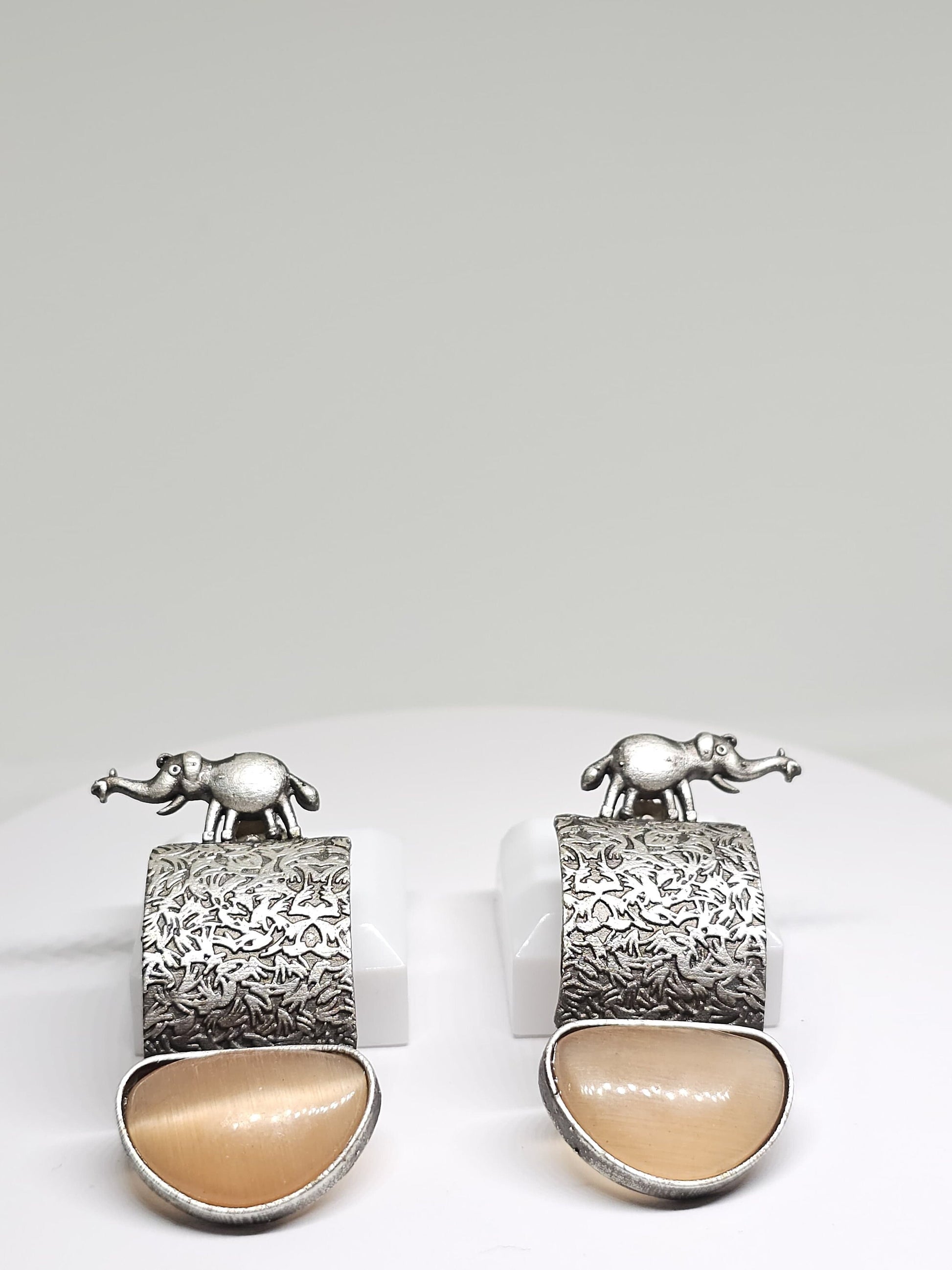 Artistic elephant-themed dangle earrings with silver and stone details