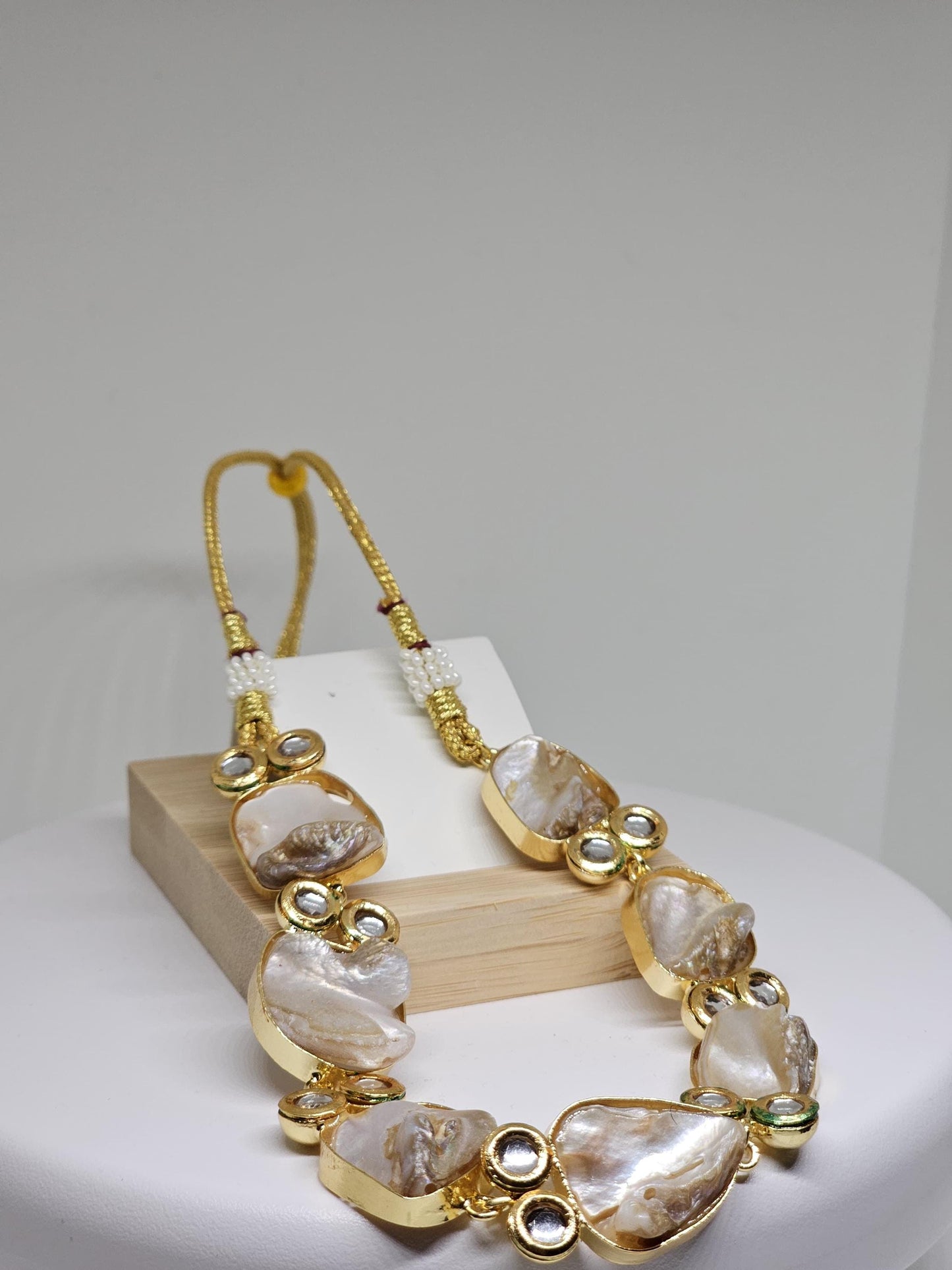 Handcrafted statement jewelry featuring mother-of-pearl stones and gold finish, paired with matching earrings for a timeless look