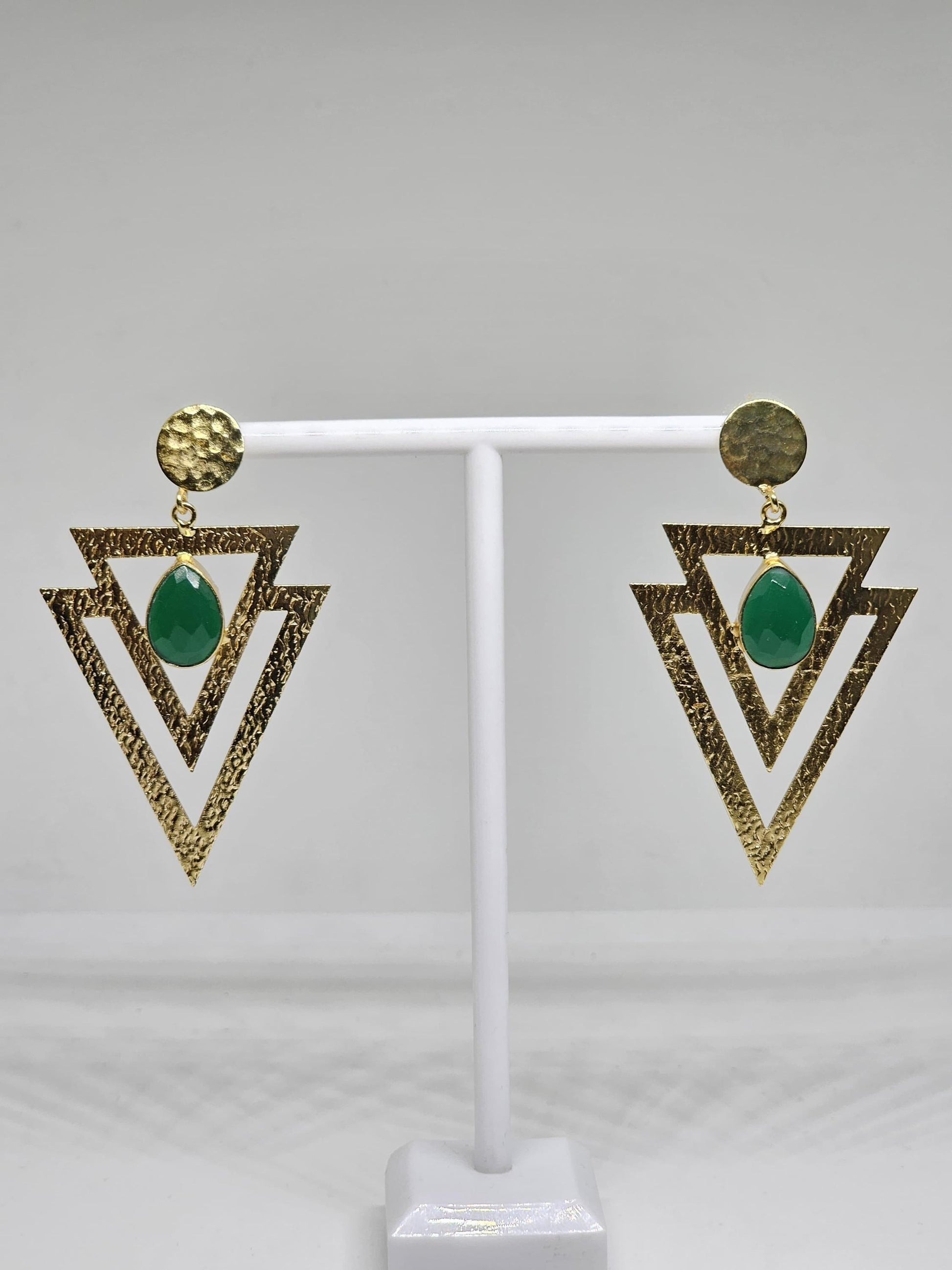 Geometric beaten brass earrings featuring layered textured triangles and a green teardrop-shaped stone, perfect for bohemian and statement looks