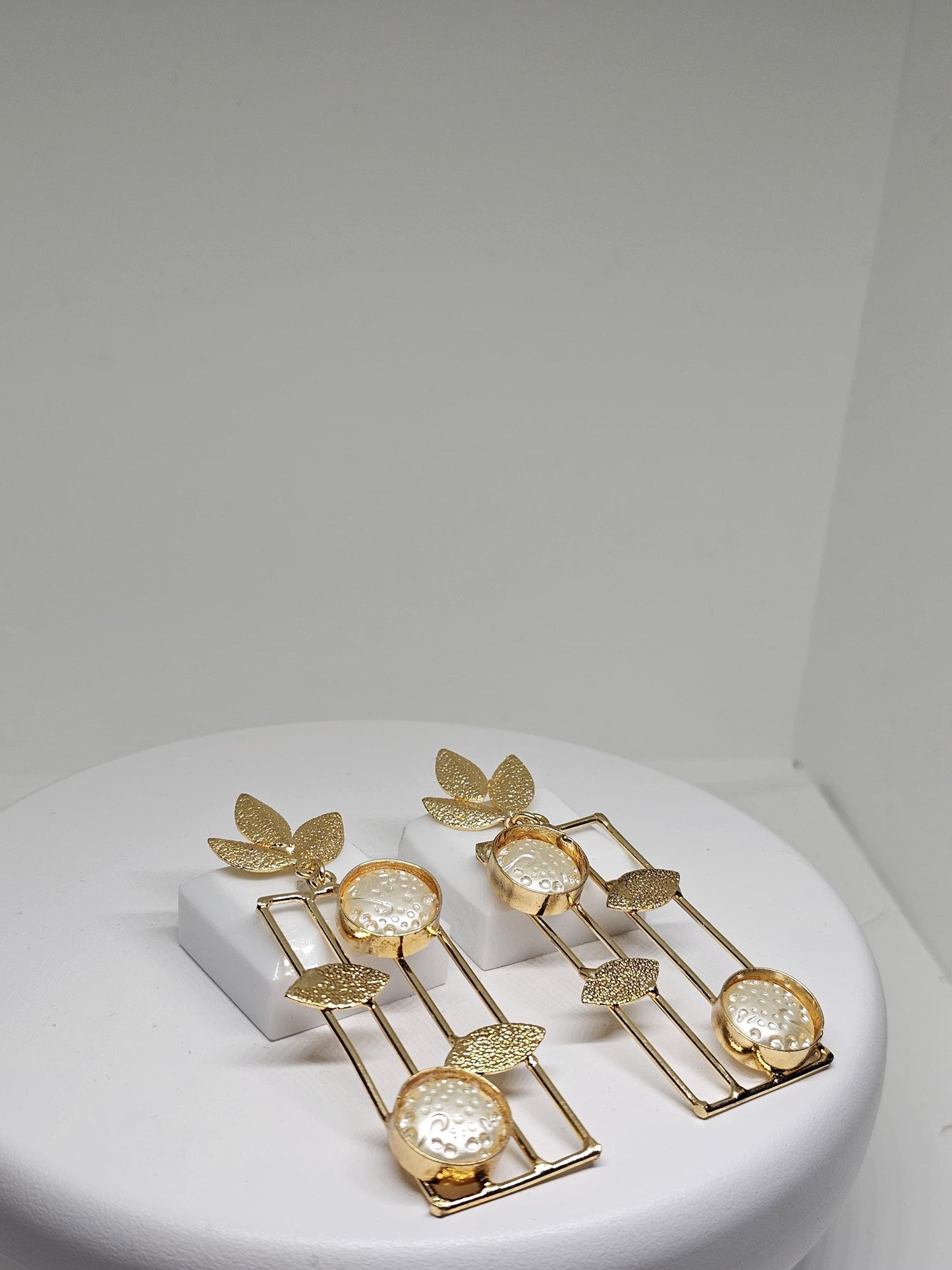 Handmade gold leaf earrings with geometric dangle design and textured circular details for women’s jewelry collection