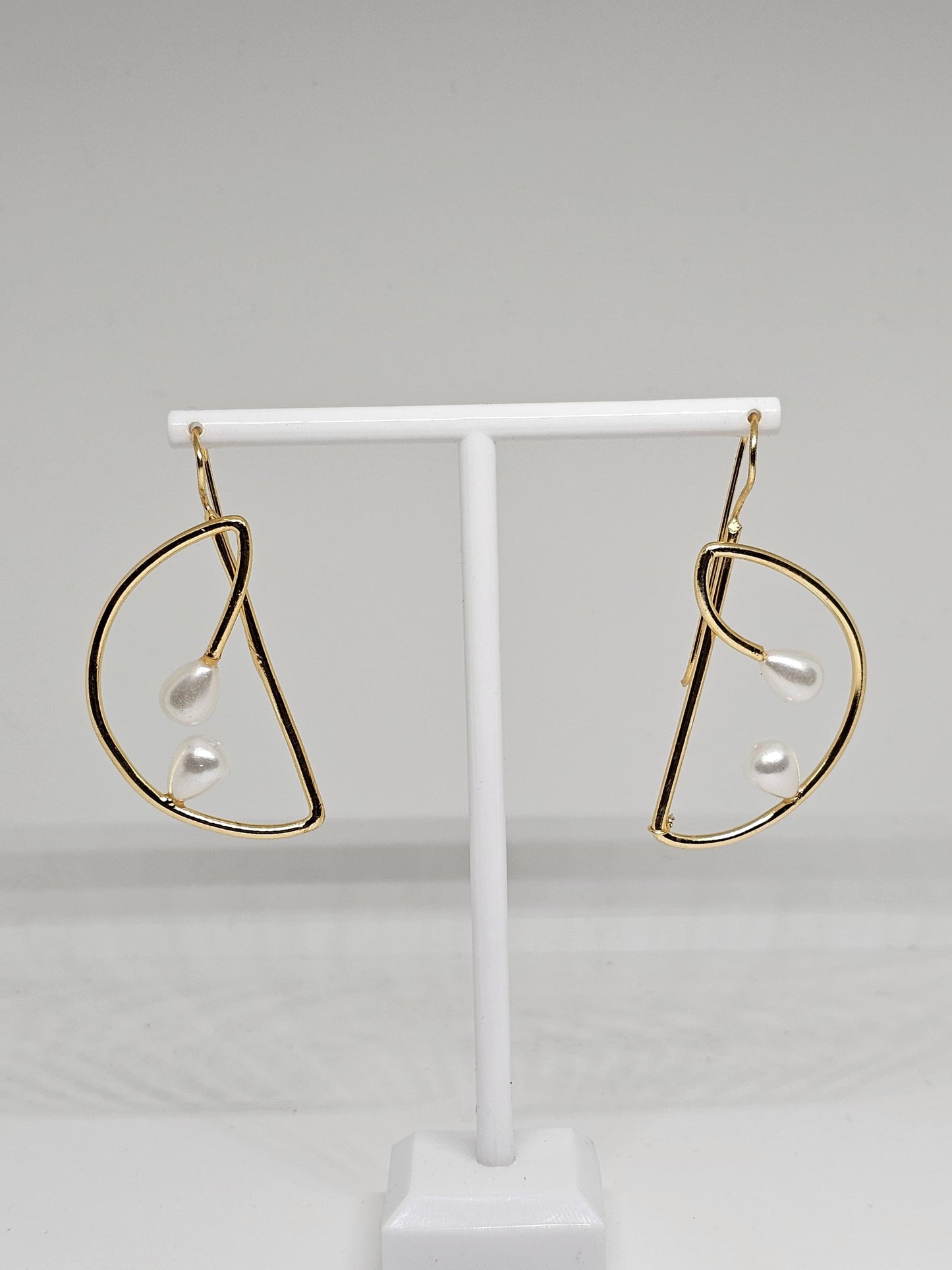 Close-up view of gold teardrop pearl earrings