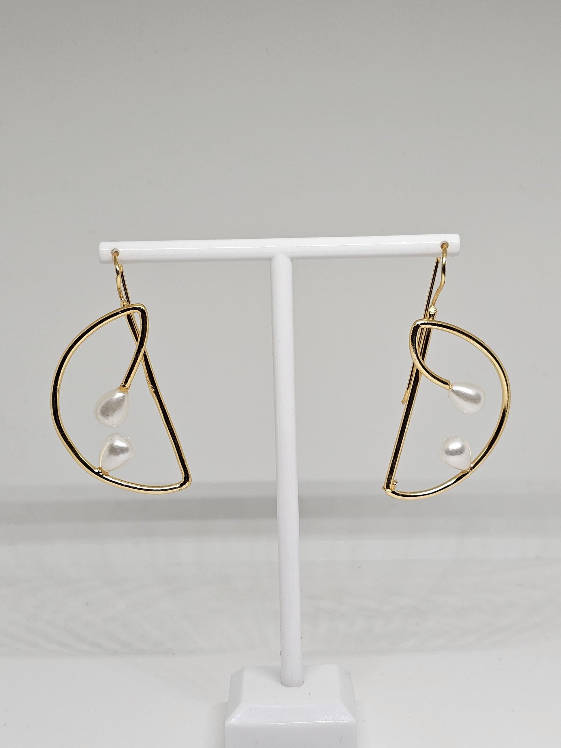 Close-up view of gold teardrop pearl earrings