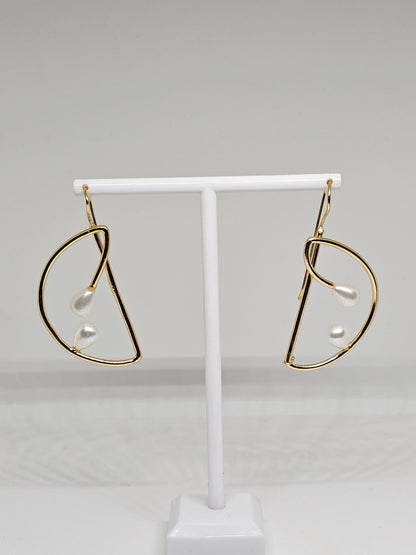 Close-up view of gold teardrop pearl earrings