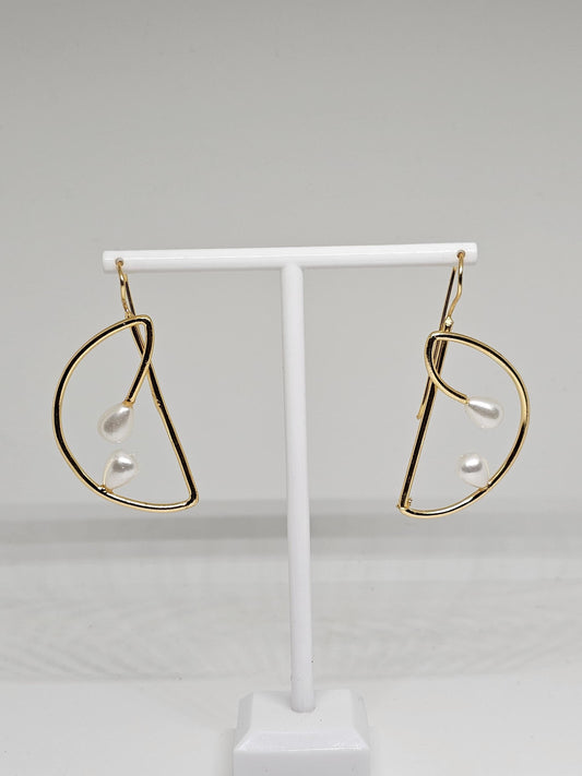 Close-up view of gold teardrop pearl earrings