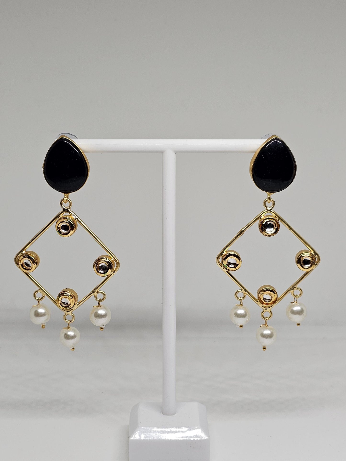 Close-up of black and gold chandelier earrings