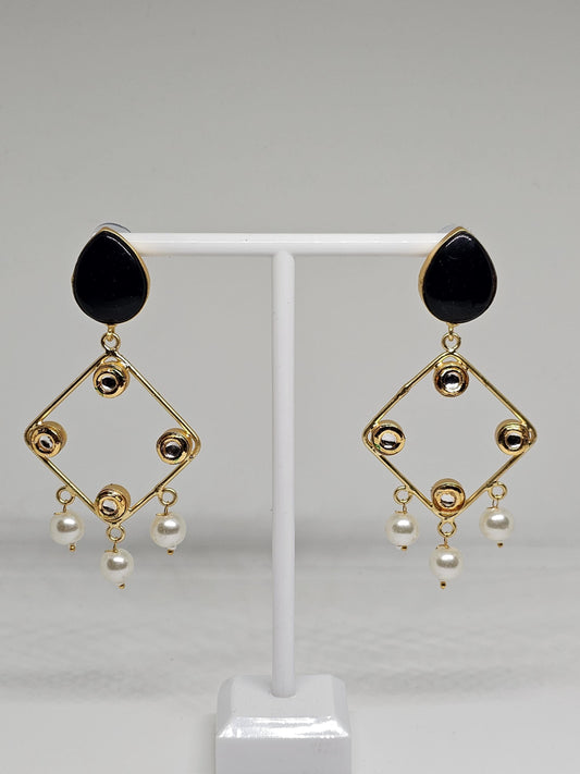 Close-up of black and gold chandelier earrings
